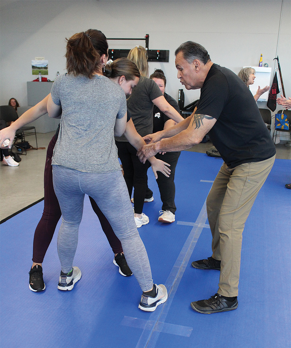 Woody Lugo, right, retired deputy from the Klamath County Sheriff's Office, demonstrates how to break a hold from an attacker at the Oct. 5 self-defense training session on the KCC campus. (KCC photo)