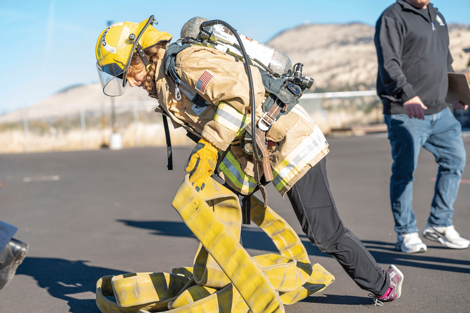 Jessica Kostick, community engagement coordinator for Healthy Klamath, tries her hand at sorting out fire hoses during the strength and agility tests at Klamath Community College Nov. 8 for “Movember” health events. (Caleb Herrera/KCC photo)